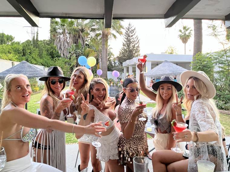Guests raising strawberry martinis at a villa party